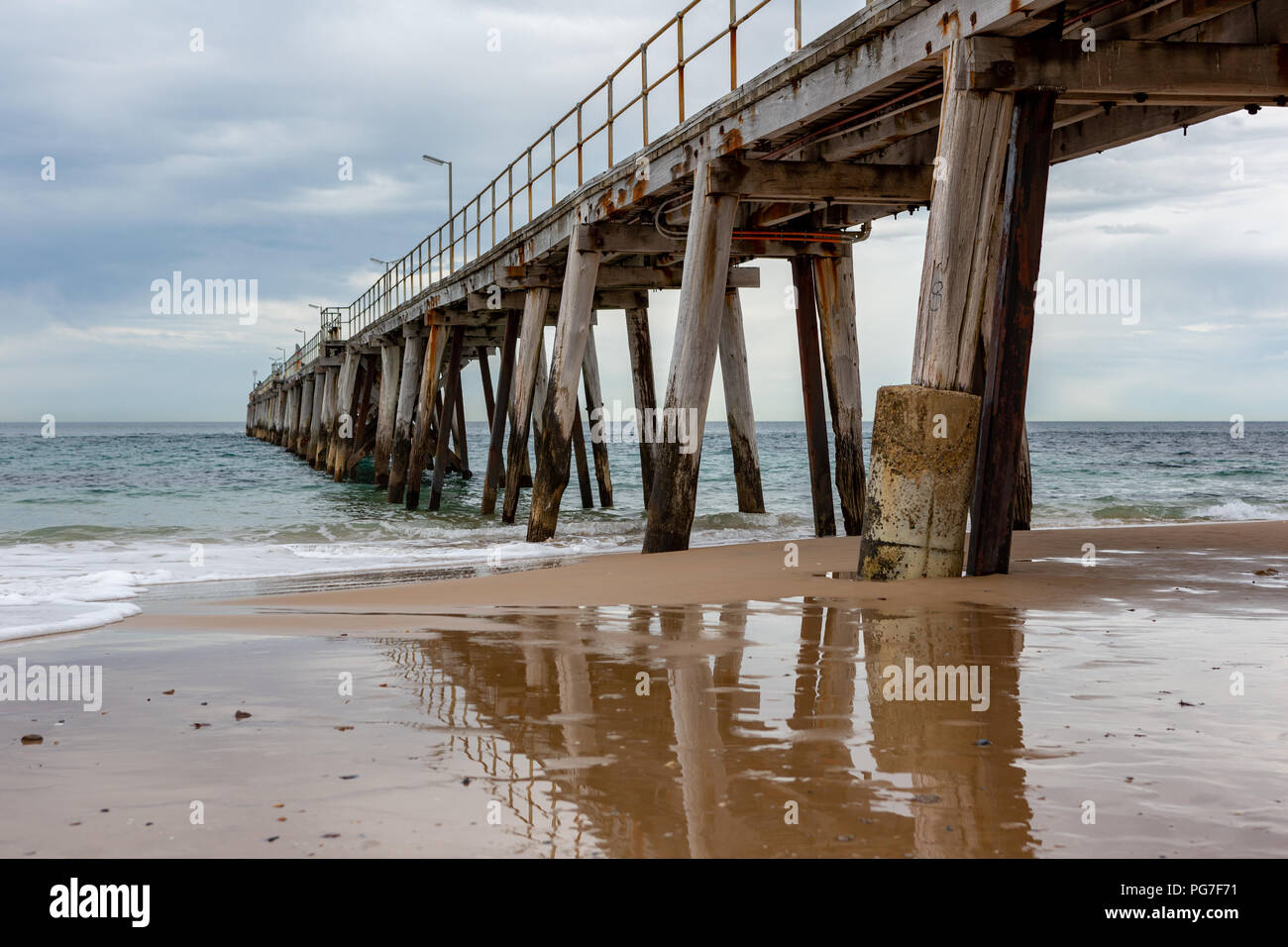 The iconic Port Noarlunga Jetty and its reflection in the water below locatedin South Australia on 23rd August 2018 Stock Photo