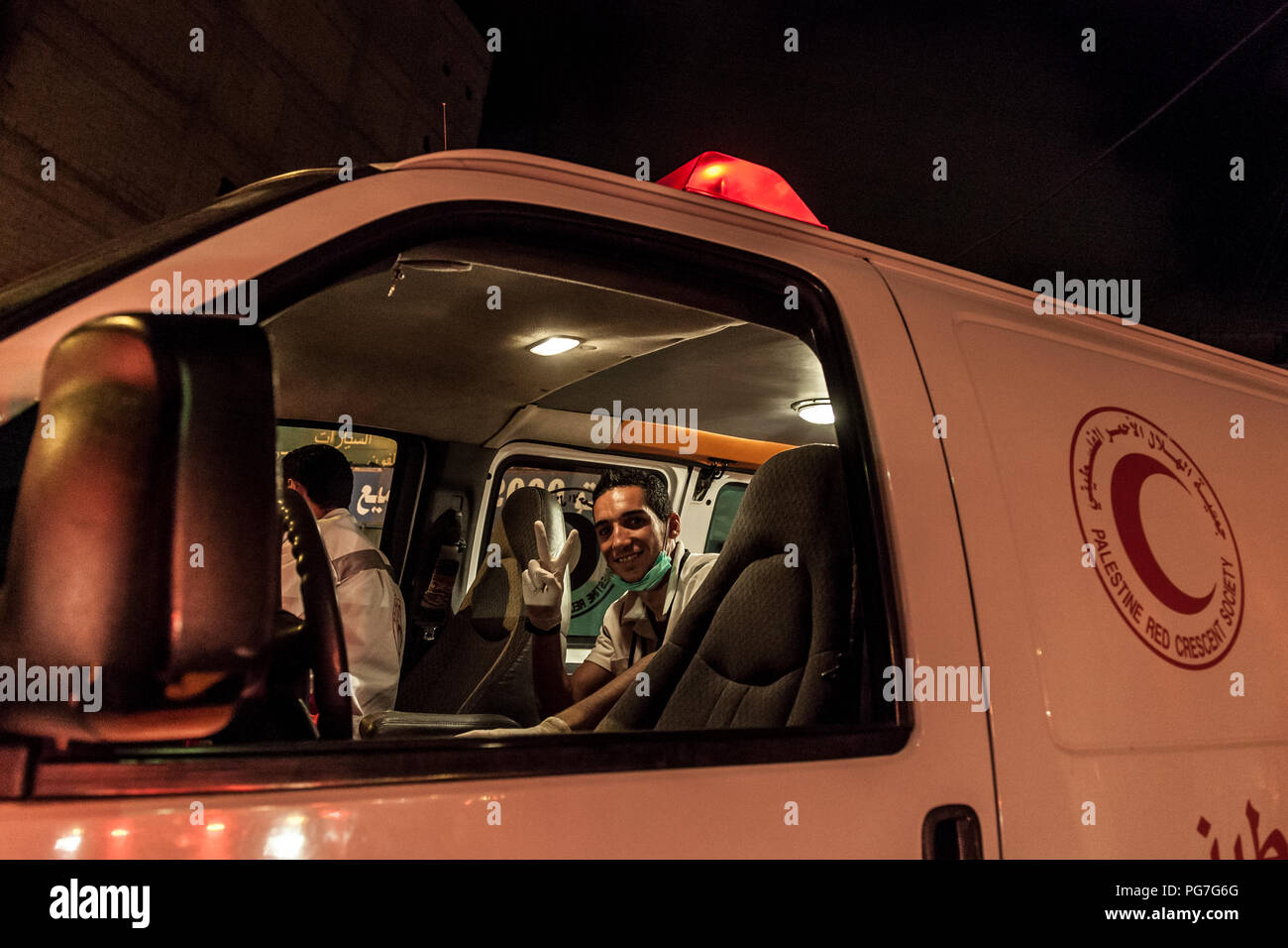 Bethlehem, Palestine, July 23, 2014: A paramedic is sitting in red crescent ambulance, waiting to be called to casualties in Bethlehem during the nigh Stock Photo
