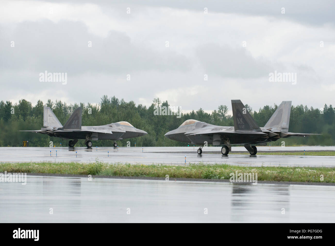 Air Force Col. Richard Koch, left, and Lt. Gen. Ken Wilsbach, taxi their F-22 Raptors while preparing to take off for Wilsbach’s final flight as commander of the Alaskan Command, Alaskan North American Aerospace Defense Region and Eleventh Air Force, at Joint Base Elmendorf-Richardson, Alaska, Aug. 20, 2018. Wilsbach is a command pilot with more than 5,000 flight hours, primarily in the F-15C, MC-12 and F-22, and has flown 71 combat missions in operations Northern Watch, Southern Watch and Enduring Freedom. Koch is the commander for the 3rd Operations Group. (U.S. Air Force photo by Alejandro  Stock Photo
