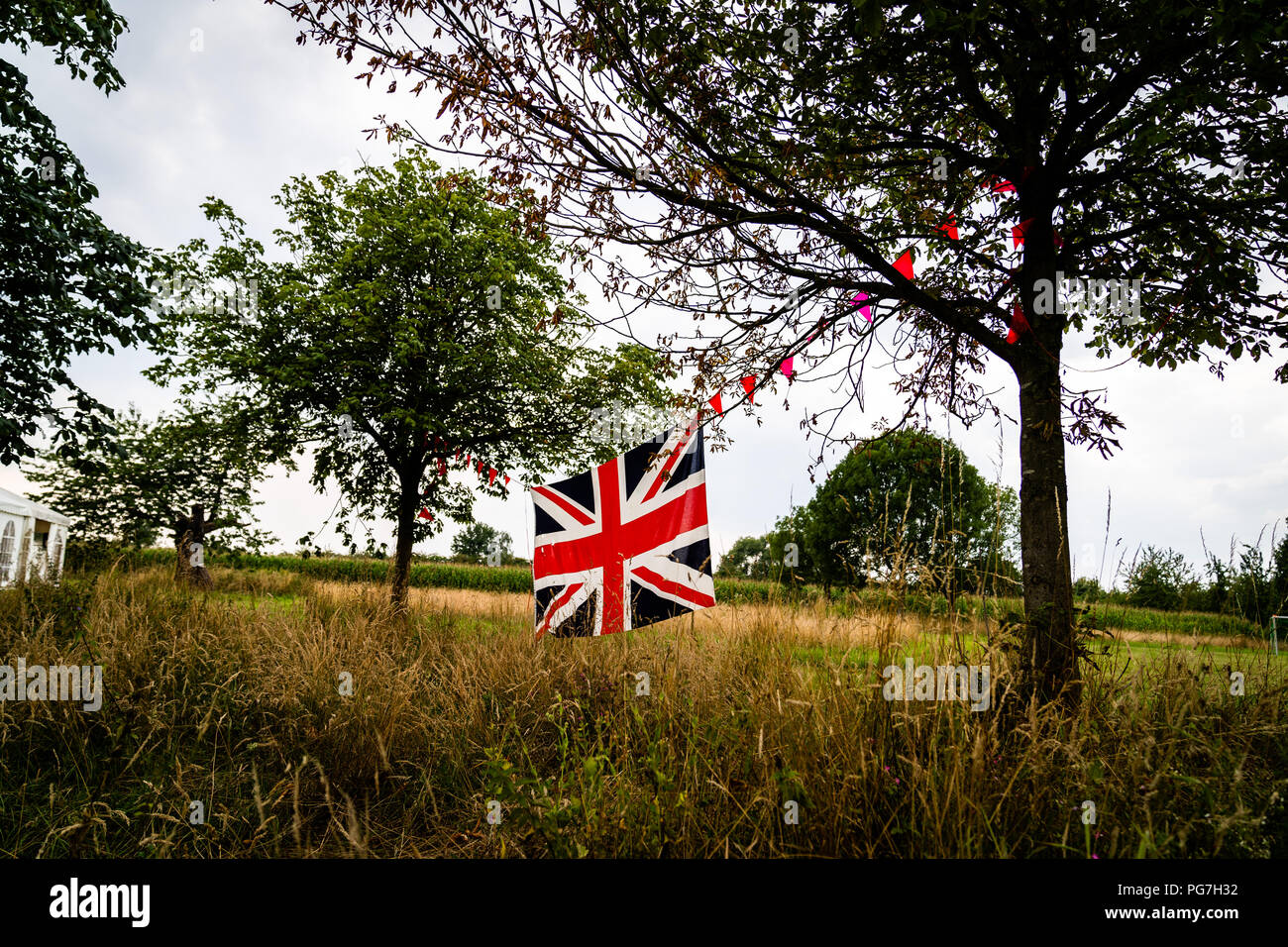 Union Jack flag stretched between trees Stock Photo
