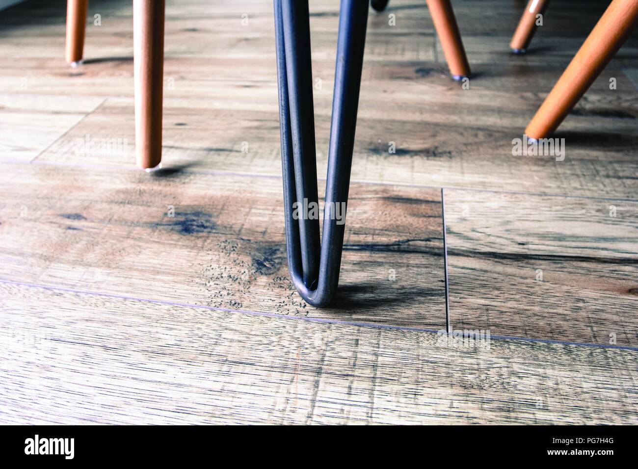 Eiffel style chair leg, in a modern living space - with wooden laminate flooring. Shows clean living, with a classic style. Stock Photo