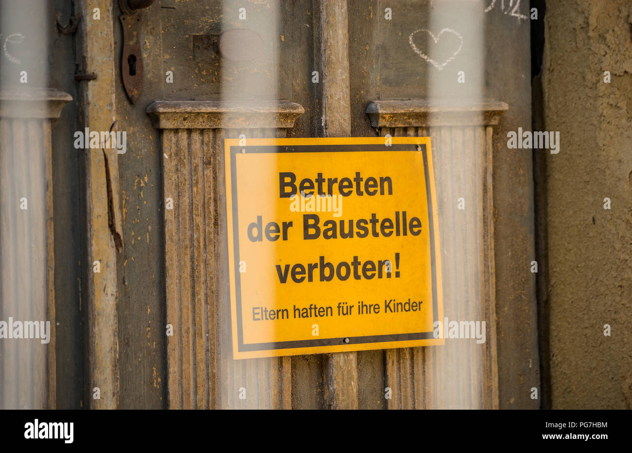 Yellow sign with the German words for BEWARE OF TRESPASSING THE CONSTRUCTION SITE Stock Photo