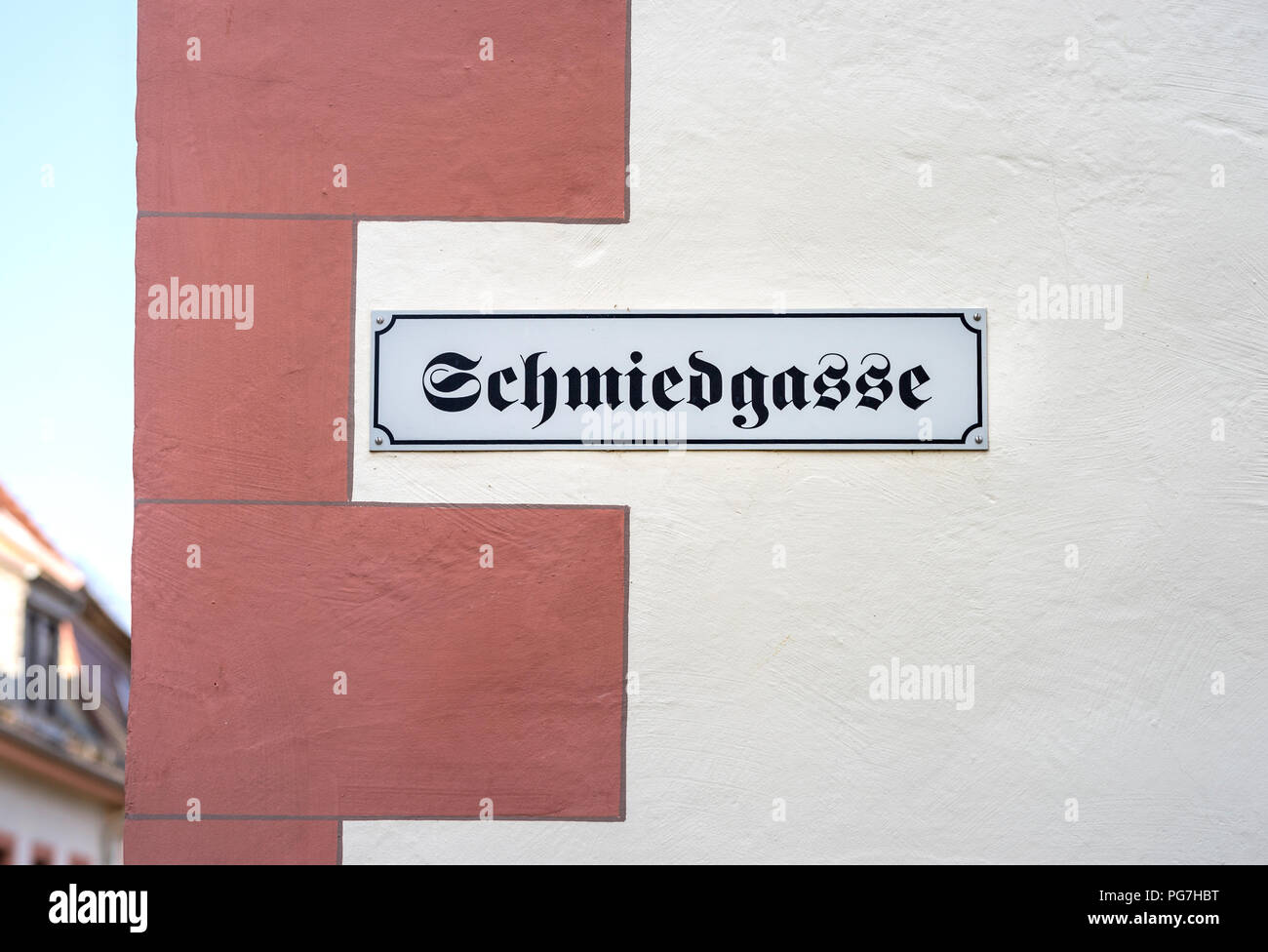 The German word for BLACKSMITH'S ALLEY hanging on a wall sign Stock