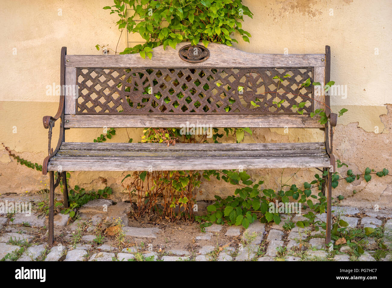 Old romantic and weathered bench in front of a wall Stock Photo - Alamy