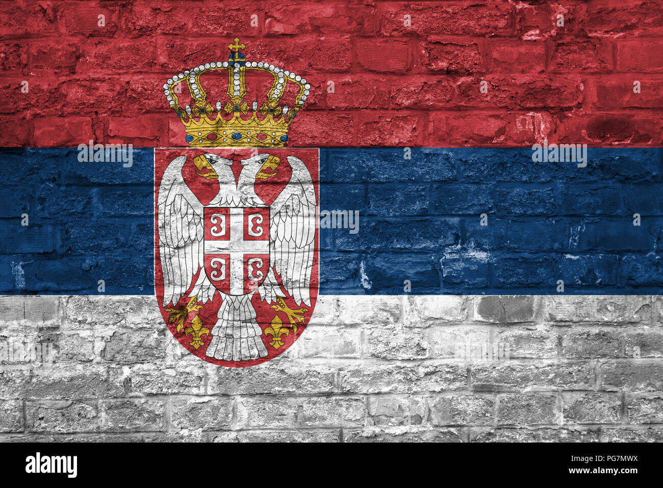 Flag of Serbia over an old brick wall background, surface Stock Photo