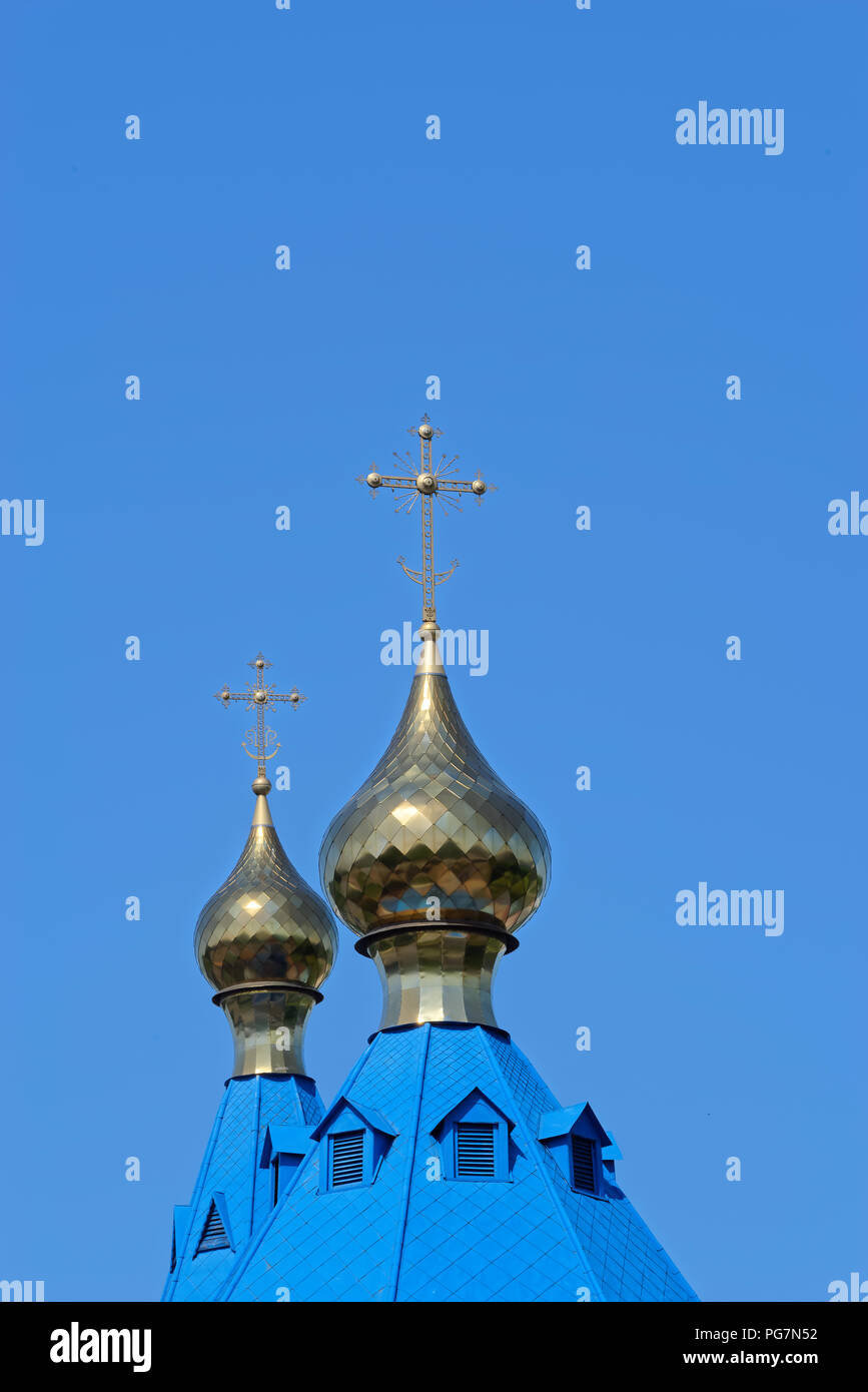 Blue roofs of russian orthodox church against clear blue sky. Cathedral of Our Lady of Kazan in Komsomolsk-on-Amur in Russia Stock Photo