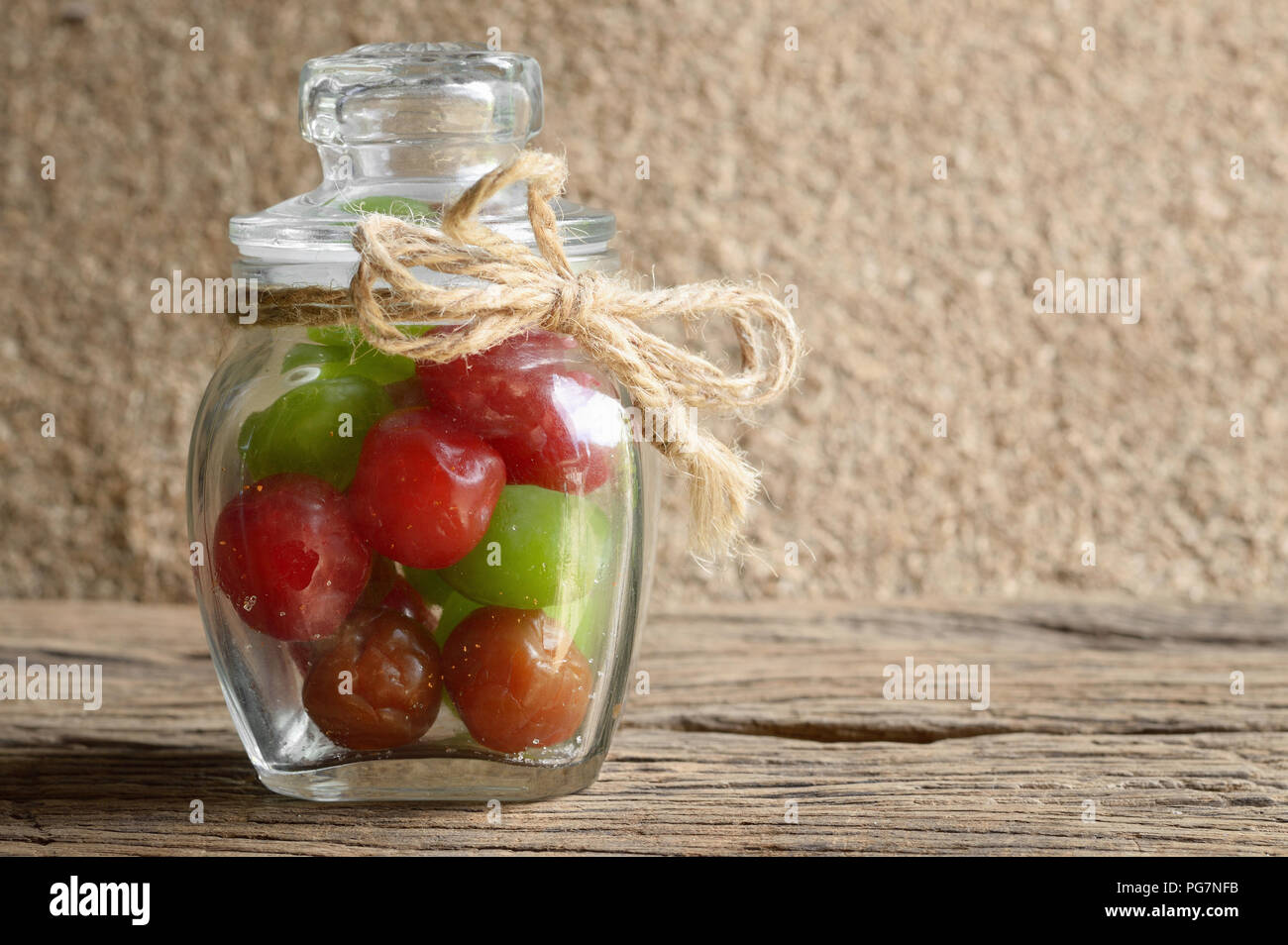 mix pickle cherry fruit in glass bottle on wooden table Stock Photo