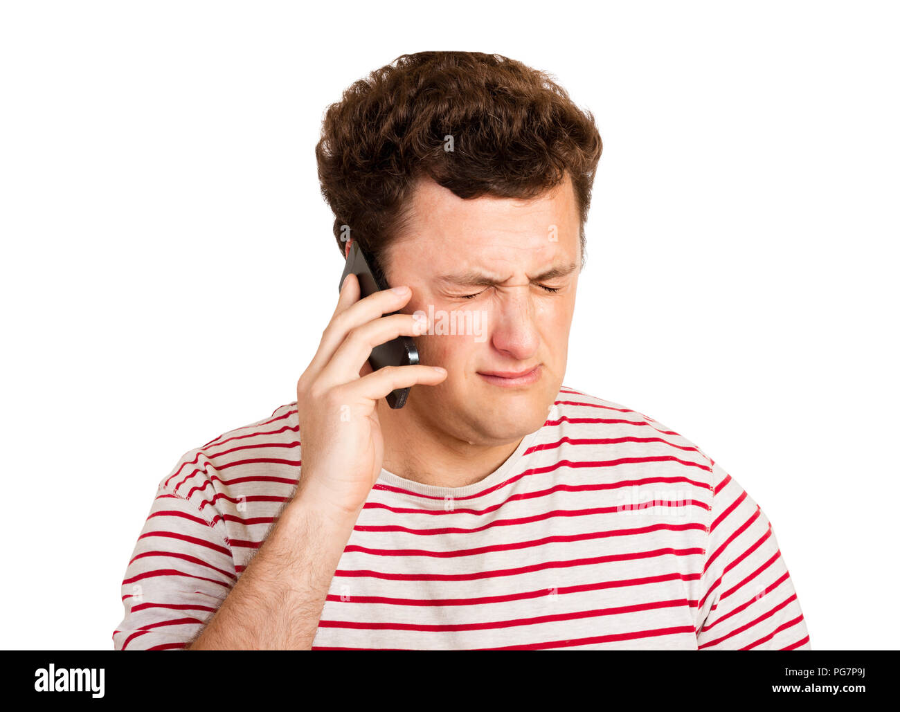 Young man crying over the bad news he is receiving on his phone. emotional man isolated on white background. Stock Photo