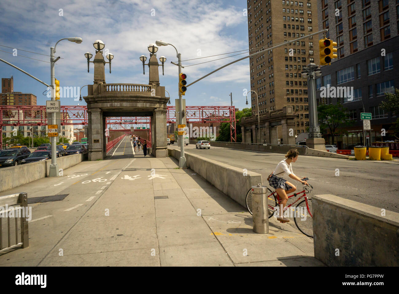 Pedestrians and bicyclists exit the Williamsburg Bridge in the Lower East Side neighborhood in Manhattan in New York on Tuesday, August 21, 2018.  (© Richard B. Levine) Stock Photo
