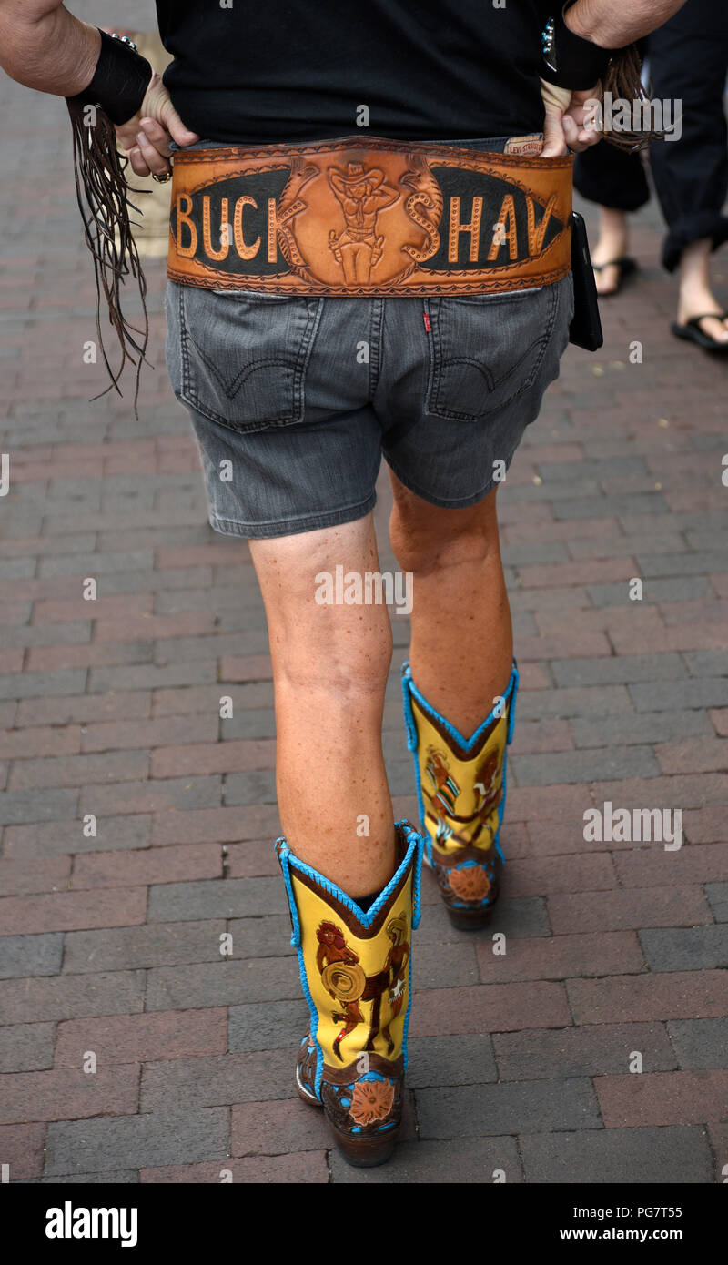 A woman wearing western boots, wide belt, Levi shorts and other western  accessories walks in Santa Fe, New Mexico Stock Photo - Alamy