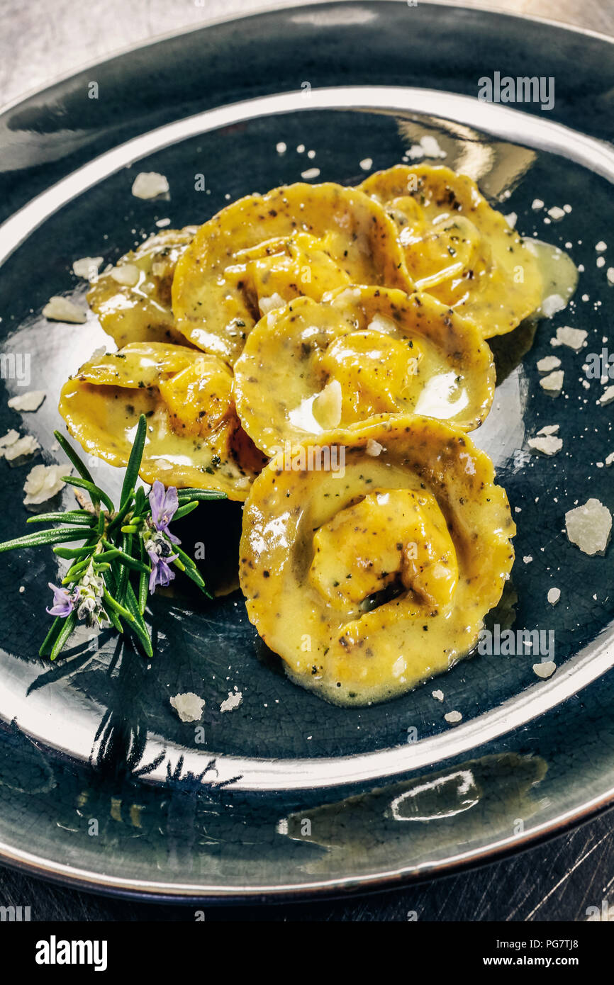 Cappelli del prete (hats of the priest): kind of homemade stuffed  fresh pasta. Dressing are made of butter, sage and rosemary. Stock Photo