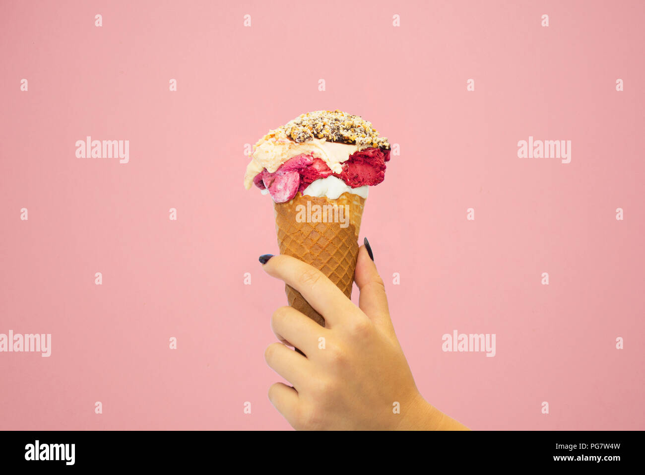 Woman hand holding an ice cream cone on a pink background Stock Photo ...
