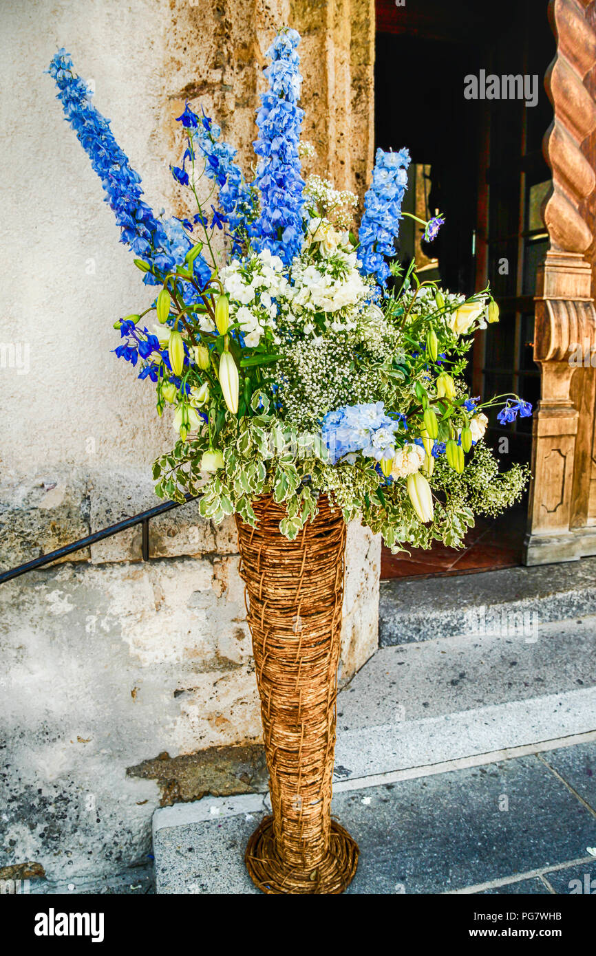 Flowers at the entrance into the church of Andrew the Apostle (Heiliger Andreas) in Kitzbuhl, Austria Stock Photo