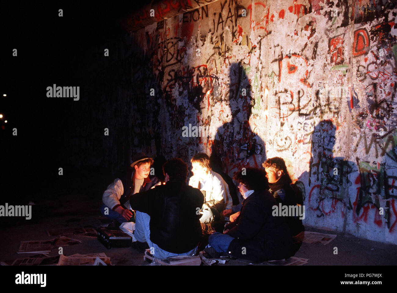 Berlin Wall 1989 - Young visitors to the Berlin Wall hold a candlelight vigil to celebrate the demolition of a section of the Wall at Potsdamer Platz. Stock Photo