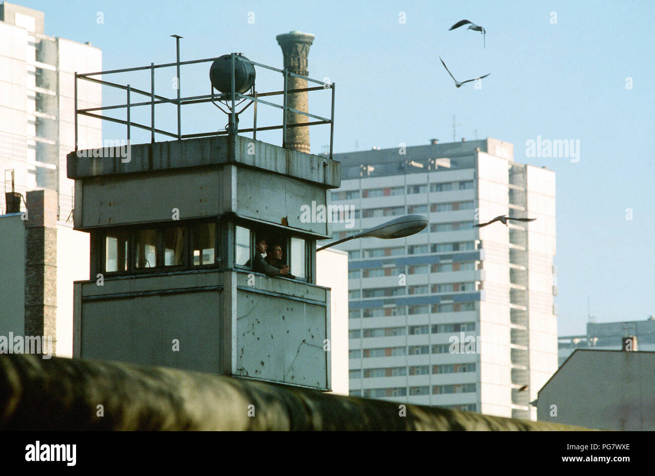 East German guards feed the birds from their post at the Berlin Wall near Checkpoint Charlie. Stock Photo