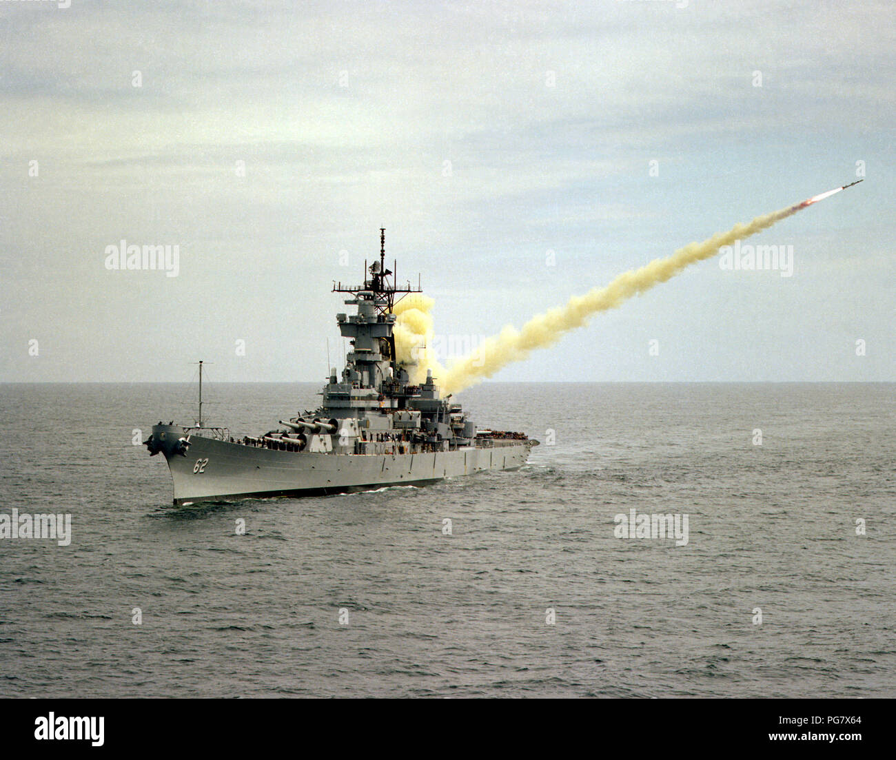 An aerial port bow view of the battleship USS NEW JERSEY (BB-62) launching an RGM-84 Harpoon missile on the Pacific Missile Test Center Range. Stock Photo
