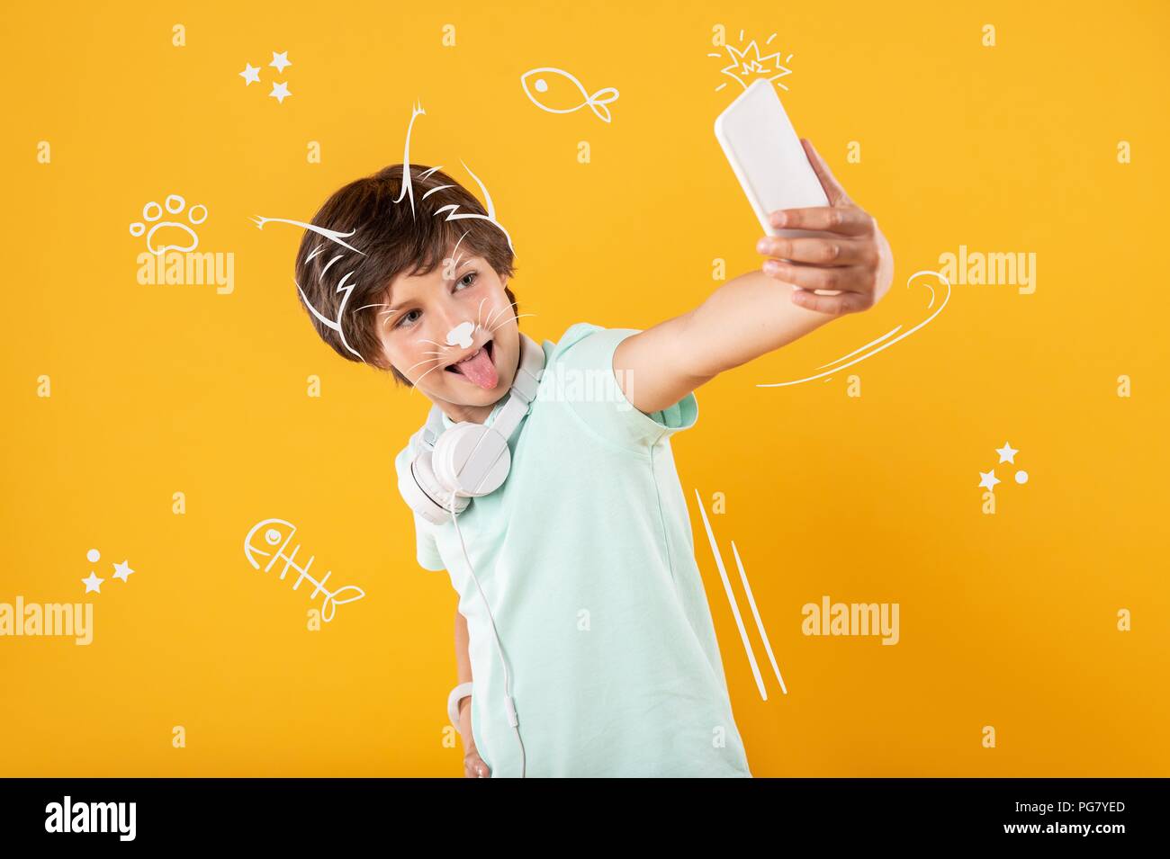 Positive boy making silly faces while taking a selfie Stock Photo