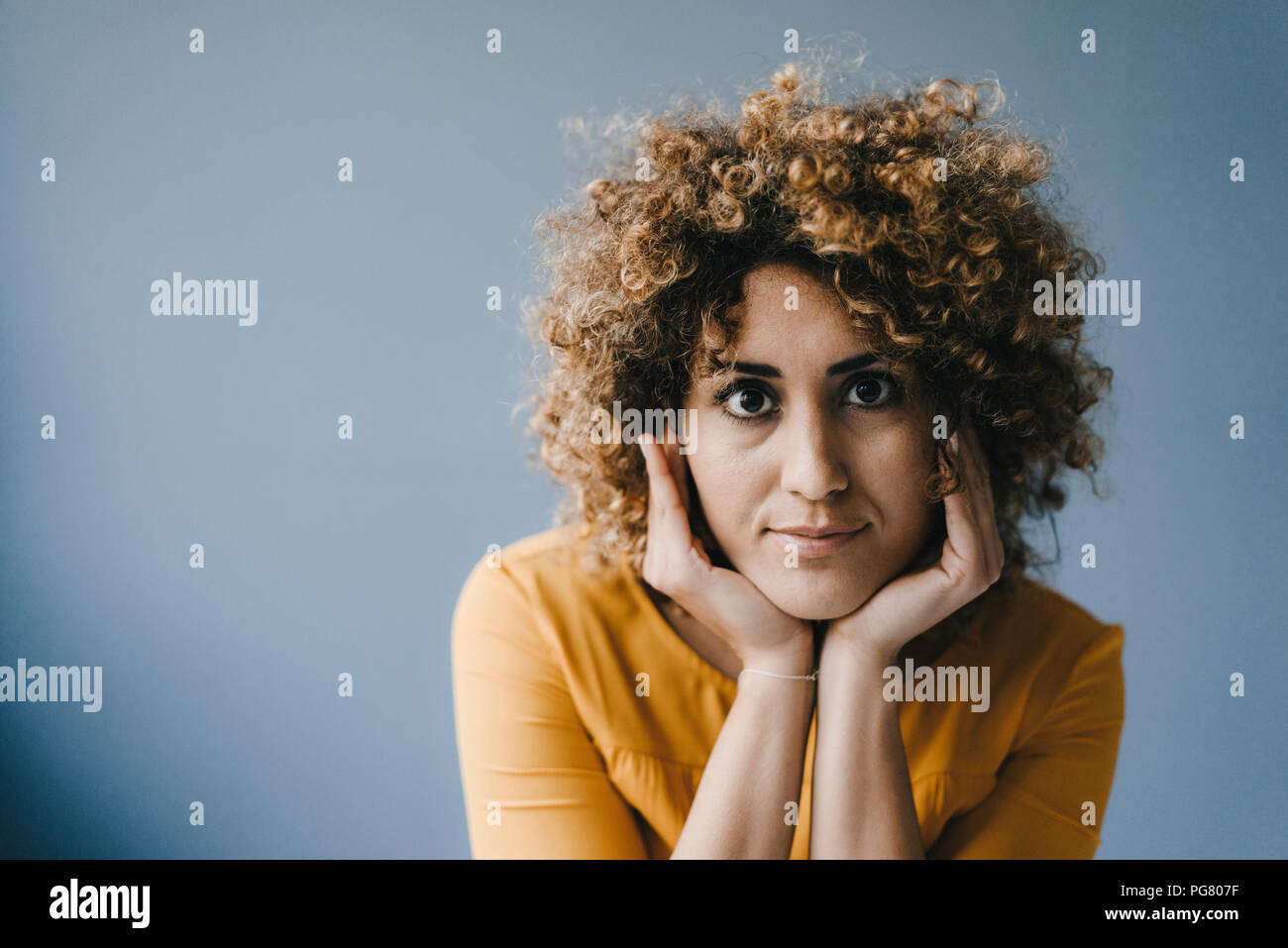 Portrait of woman with head in hands Stock Photo