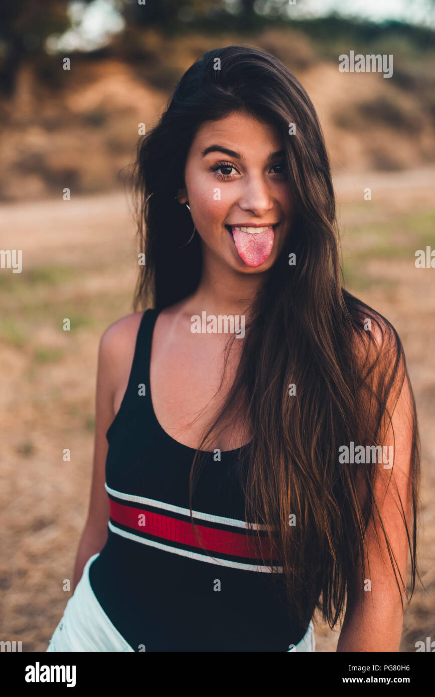 Portrait of teenage girl sticking out tongue Stock Photo