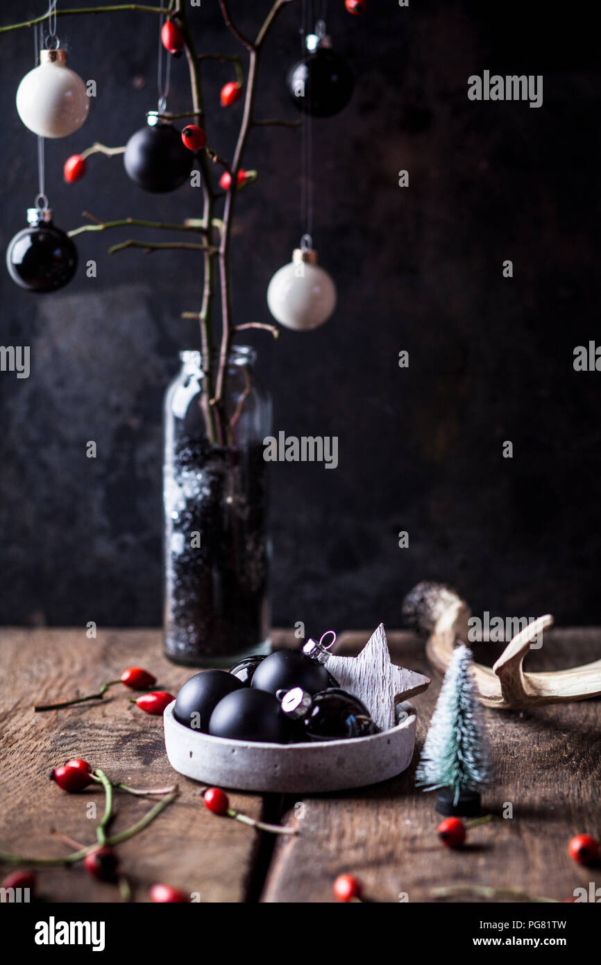Vhristmas decoration with white and black baubles and twigs with rose hips in a vase Stock Photo