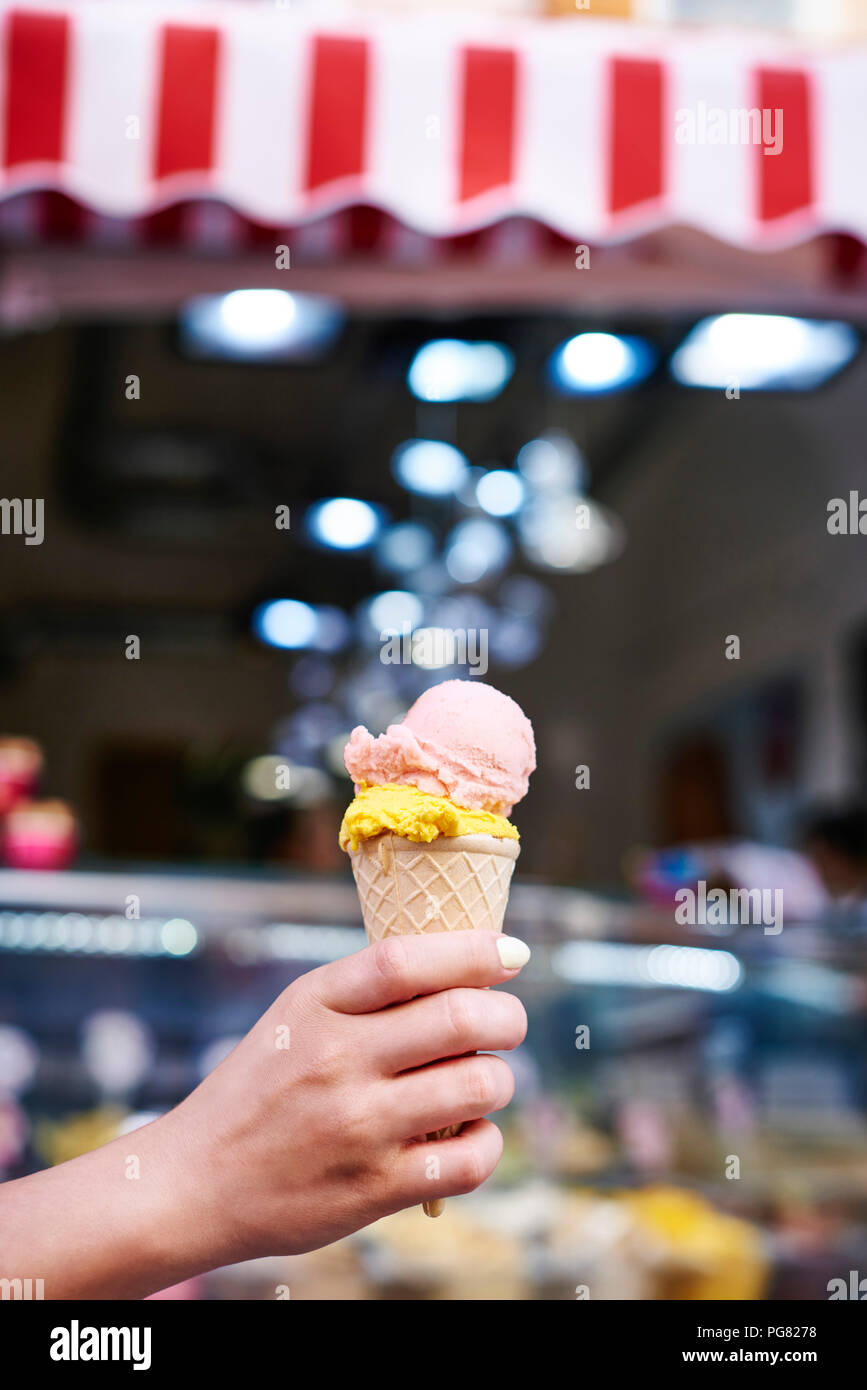 Woman's hand holding ice cream cone with two scoops Stock Photo