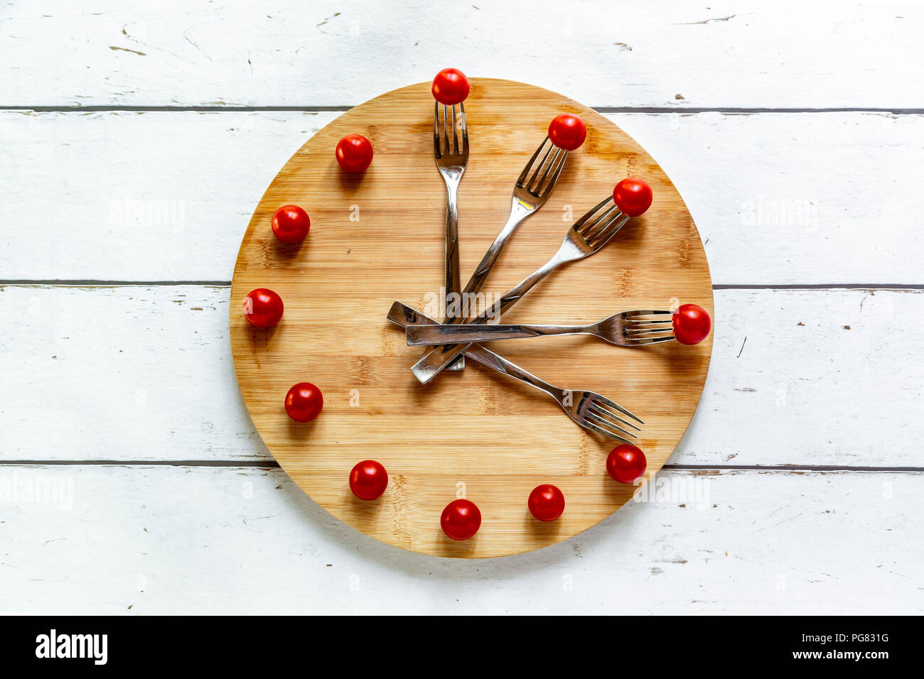 Vegetables on round chopping board, symbol for intermittent  fasting Stock Photo