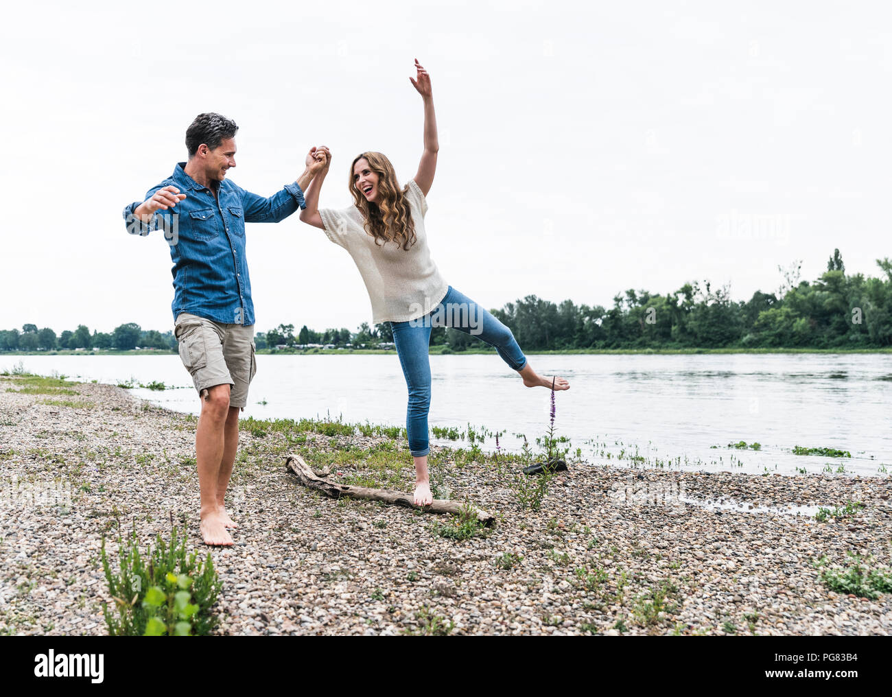 Playful couple at the riverside Stock Photo - Alamy