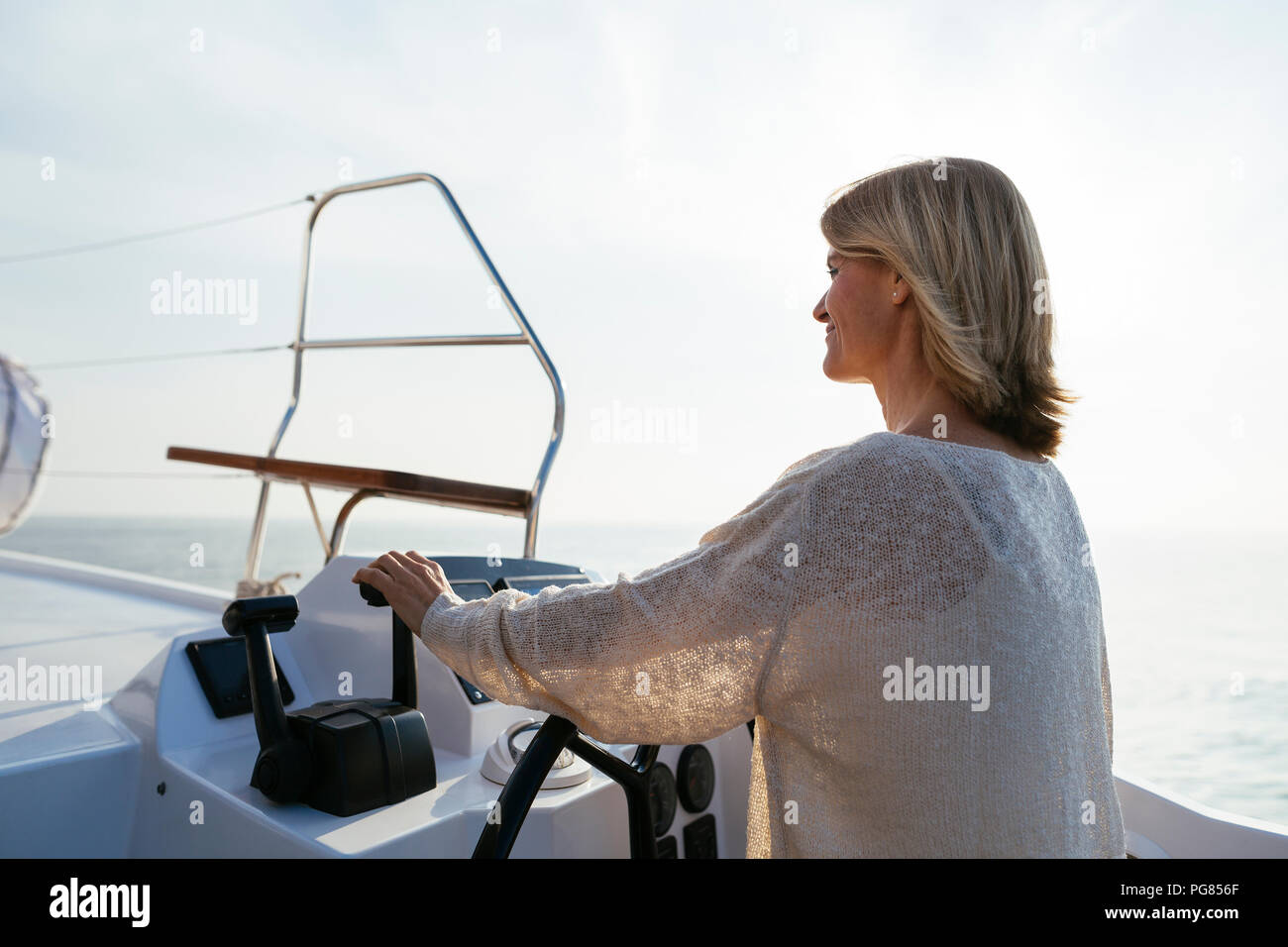 Mature woman navigating catamaran on a sailing trip Stock Photo