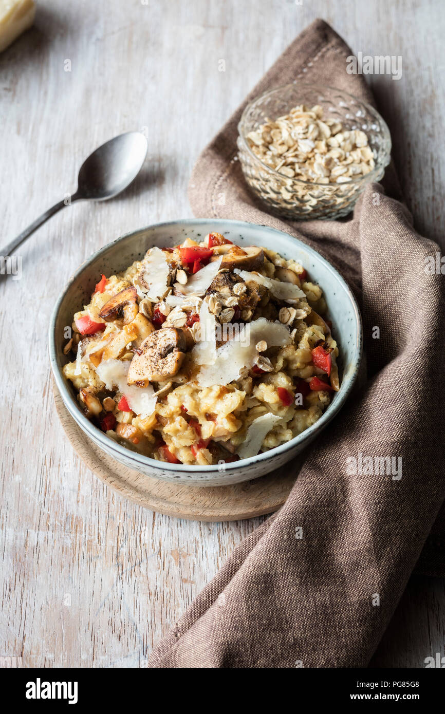 Bowl of porridge with bell pepper, champignon and parmesan Stock Photo