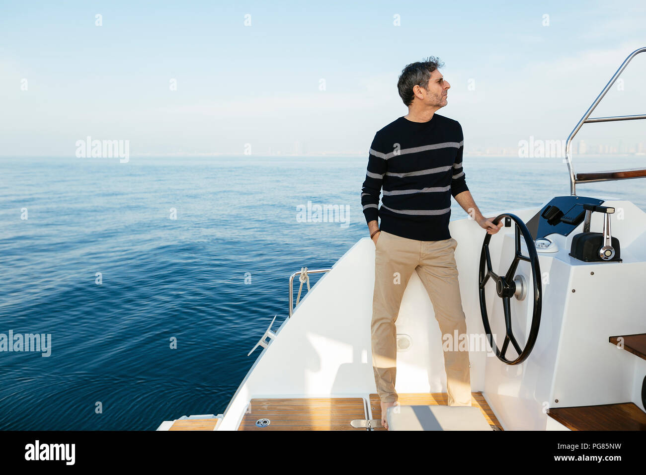 Mature man navigating catamaran on a sailing trip Stock Photo