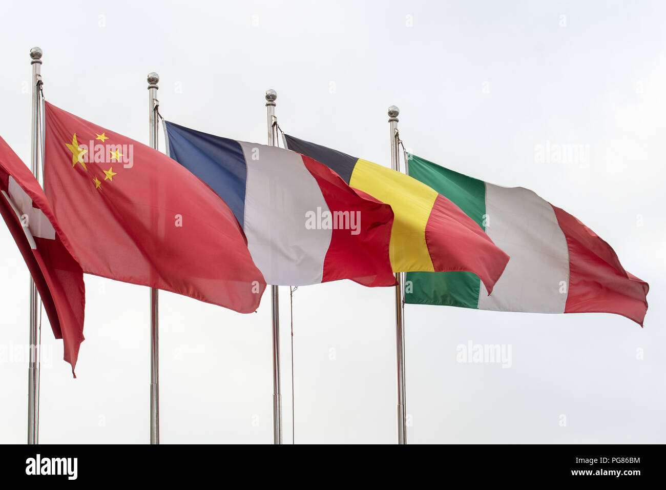 Flags of Italy, Germany, France, China and Switzerland flying from poles Stock Photo