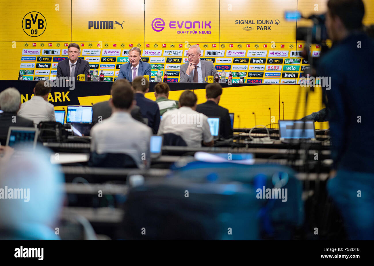 Dortmund, Germany. 24th Aug, 2018. Sascha Fligge (l-r), Spokesman of Borussia Dortmund, Hans-Joachim Watzke, Managing Director of Borussia Dortmund, and Thomas Treß, Managing Director Finance, sit at the Annual Press Conference of Borussia Dortmund GmbH & Co.KGaA for fiscal year 2017/2018. Credit: Guido Kirchner/dpa/Alamy Live News Stock Photo