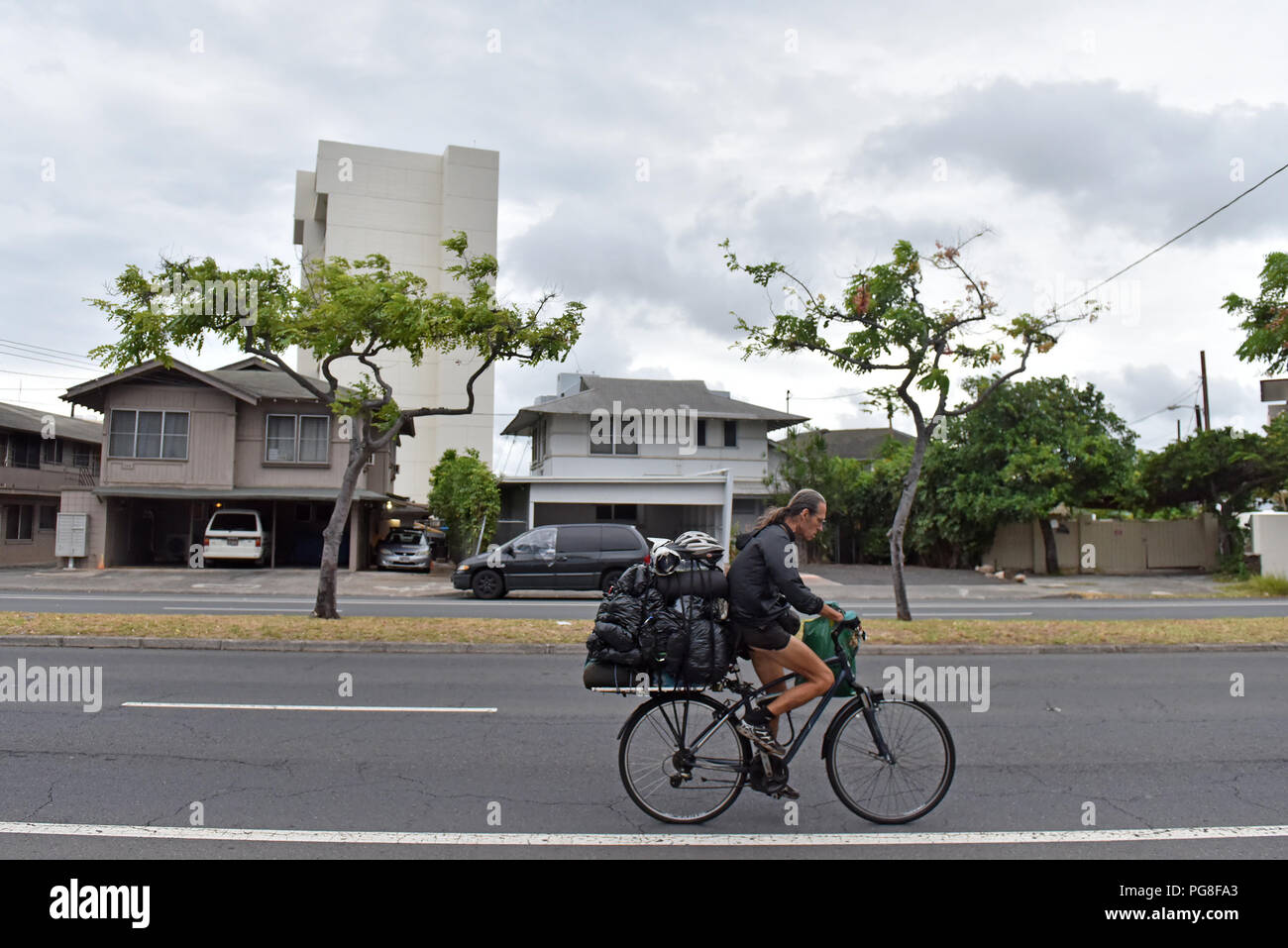 (180824) -- HONOLULU, Aug. 24, 2018 (Xinhua) -- A homeless man rides a bicycle to look for a new location to camp in Honolulu of Hawaii, the United States, Aug. 23, 2018. Hurricane Lane, predicted as the biggest weather threat to Hawaii in decades, moved perilously close to the Aloha State Thursday morning, triggering heavy rain, landslide and flooding. (Xinhua/Sun Ruibo) (dtf) Stock Photo