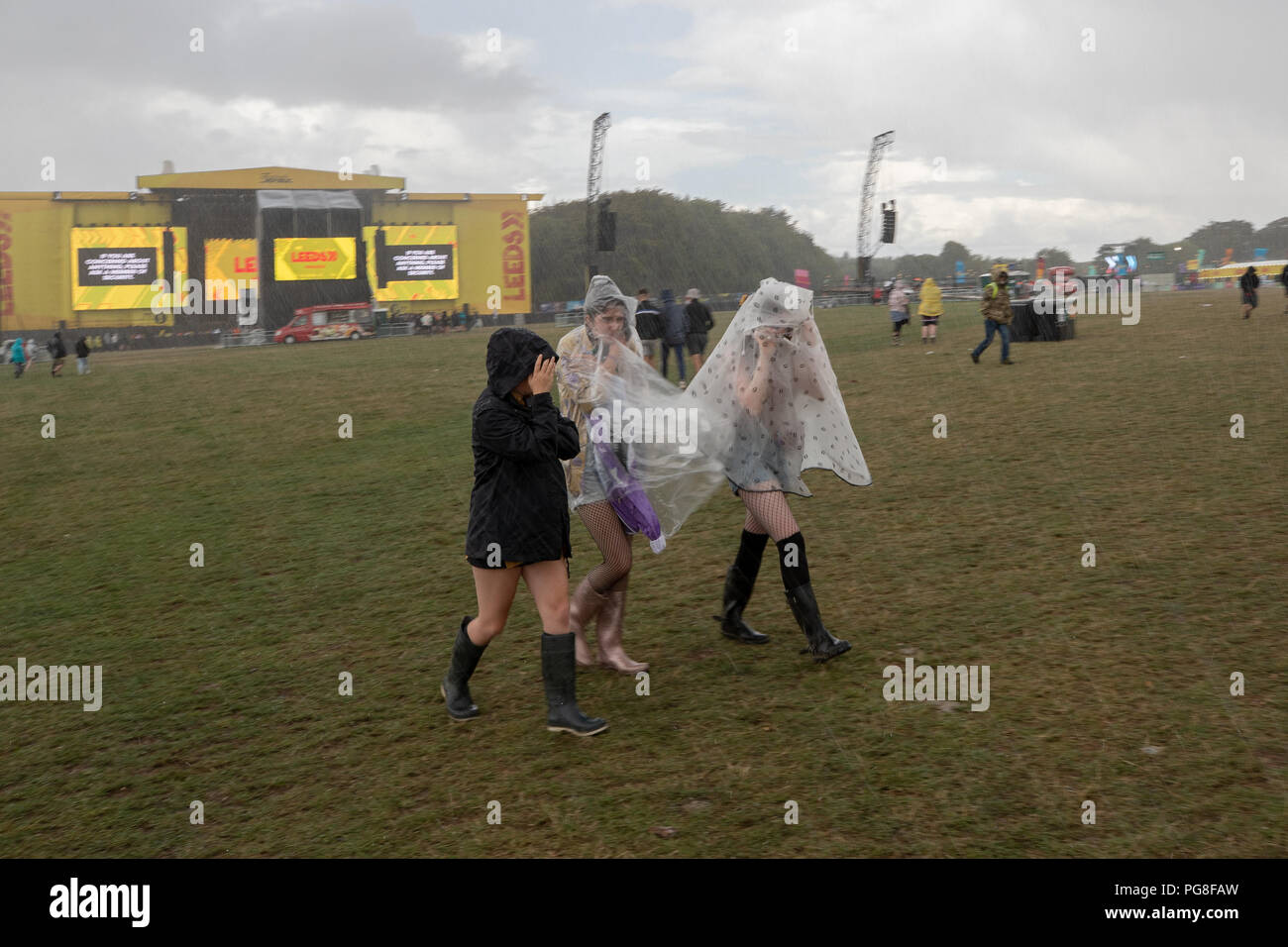 Bramham Park, UK. 24th August 2018, UK Weather. People sheltering from the torrential rain at Leeds Festival during a hail storm ,Yorkshire,UK. © Jason Richardson / Alamy Live News Stock Photo