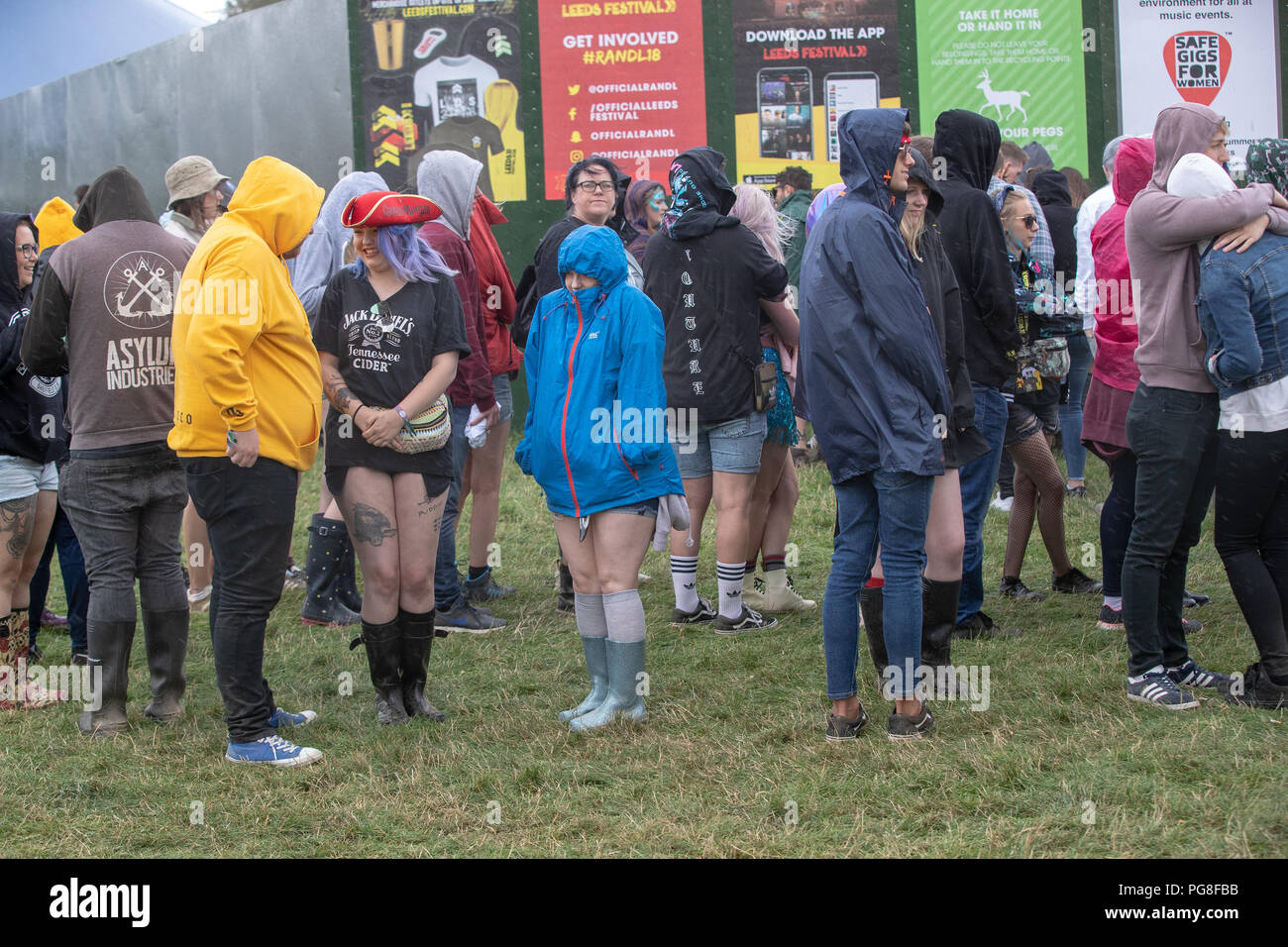 Bramham Park, UK. 24th August 2018, UK Weather. People sheltering from the torrential rain at Leeds Festival during a hail storm ,Yorkshire,UK. © Jason Richardson / Alamy Live News Stock Photo