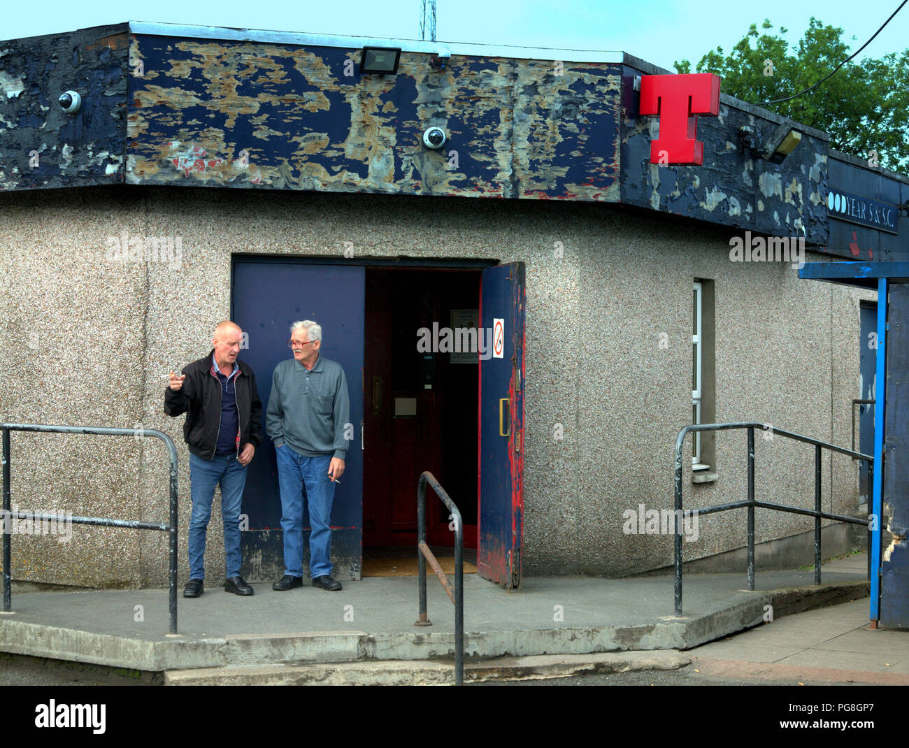 Glasgow, Scotland, UK. 24th Aug, 2018. UK Weather: Brighter weather sees locals unsure of rain or shine as life goes and locals discuss the weather at the door of Goodyear Sports & Social Club in Drumchapel. Credit: gerard ferry/Alamy Live News Stock Photo