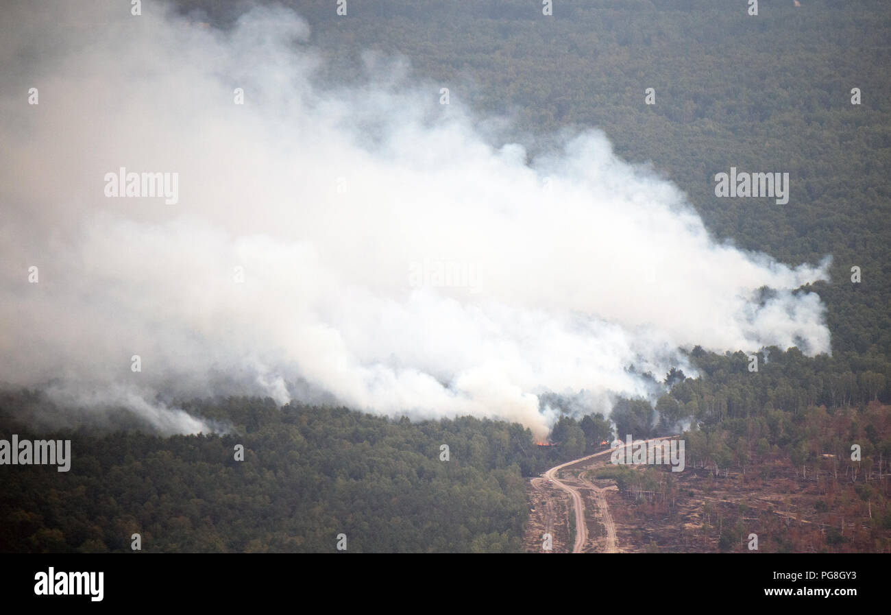 Frohnsdorf, Germany. 24th Aug, 2018. A path runs through a burning piece of forest. Hundreds of emergency forces contained the huge forest fire southwest of Berlin on Friday, but have not yet brought it under control. Credit: Ralf Hirschberger/dpa/Alamy Live News Stock Photo