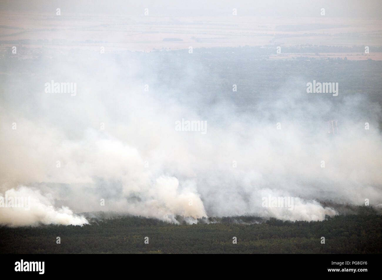 Frohnsdorf, Germany. 24th Aug, 2018. clouds of smoke move over a burning piece of forest. Hundreds of emergency forces contained the huge forest fire southwest of Berlin on Friday, but have not yet brought it under control. Credit: Ralf Hirschberger/dpa/Alamy Live News Stock Photo