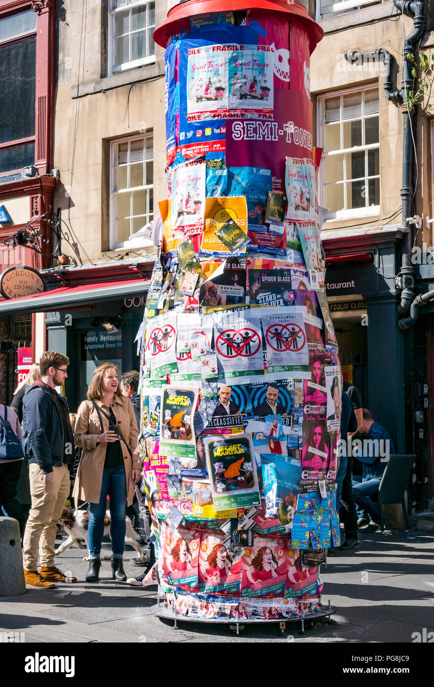 Edinburgh Fringe Festival, Edinburgh, Scotland, UK. 24th August 2018.  The sun shines on Fringe goers at the Virgin Money sponsored street venue on the Royal Mile. The temporary poles for fringe posters grow fatter as the weeks go by as Fringe performers paste posters on top of each other Stock Photo