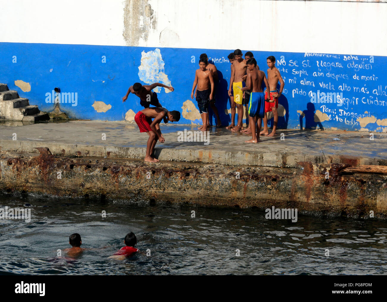 Puerto Cabello, Carabobo, Venezuela. 24th Aug, 2018. August 24, 2018. Young residents play games that end up in the sea, in the malecon of Puerto Cabello, Carabobo state. Photo: Juan Carlos Hernandez Credit: Juan Carlos Hernandez/ZUMA Wire/Alamy Live News Stock Photo