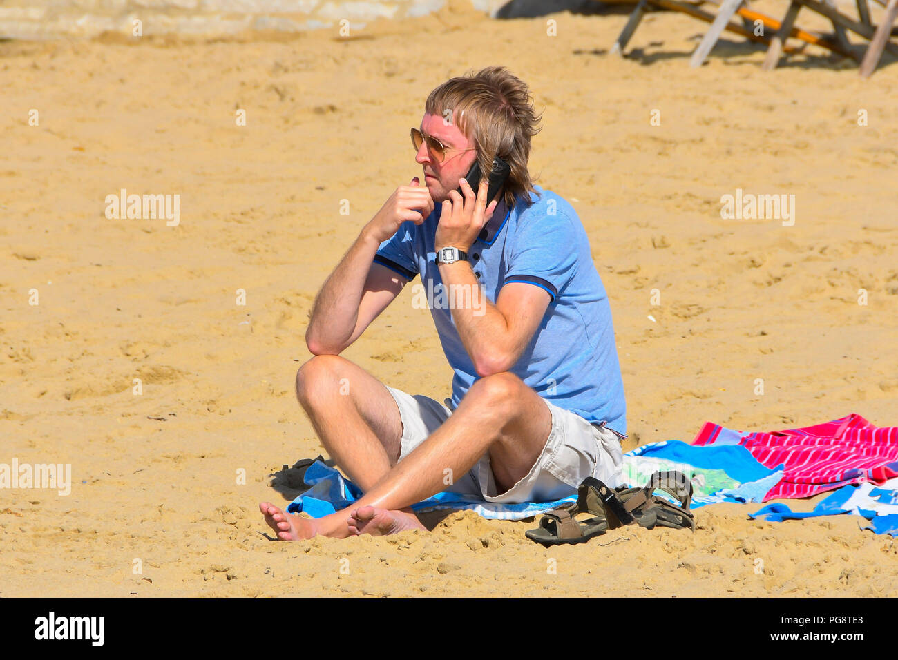 Boscombe, Bournemouth, Dorset, UK.  25th August 2018. UK Weather.  A sunbather enjoying a morning of warm sunshine and blue skies on the beach at Boscombe near Bournemouth in Dorset.  Picture Credit: Graham Hunt/Alamy Live News Stock Photo