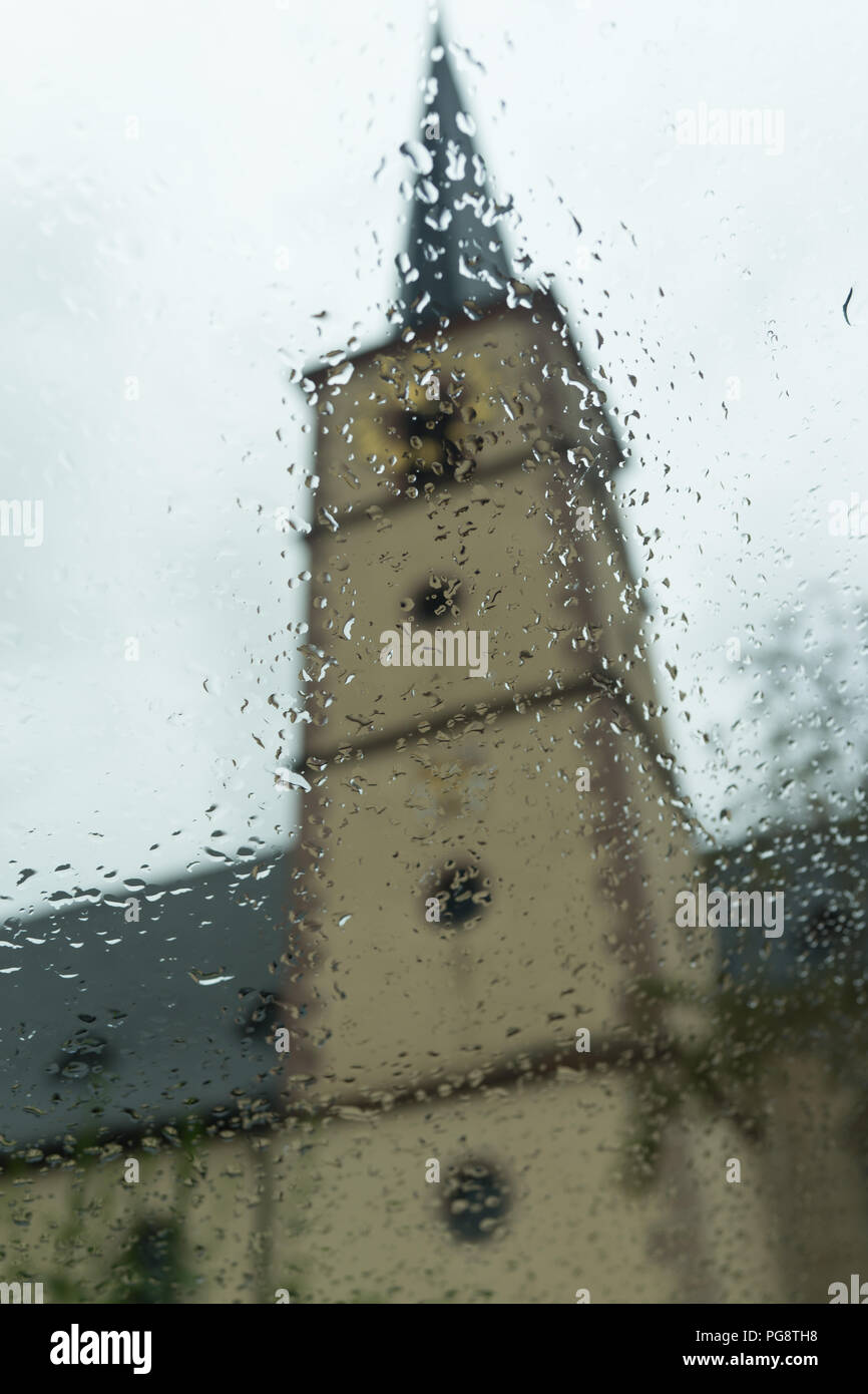 Oberschwarzach Bavaria Germany, Saturday 25 August 2018 / Dramatic weather change in late summer. The dry and hot European summer turns into a cold and rainy pre autumn. The church tower in the background is blurred by the start of cold morning rain. Credit: Ingo Menhard/Alamy Live News Stock Photo