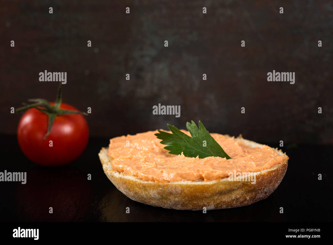 Appetizer made from one slice of bread with cod and almon roe salad on dark slate Stock Photo