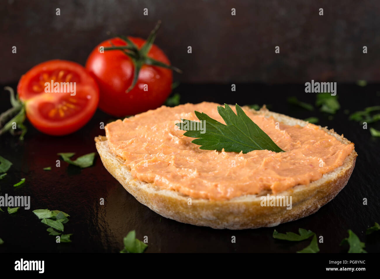 Appetizer made from one slice of bread with cod and almon roe salad on dark slate Stock Photo