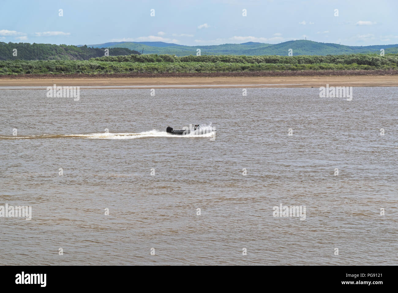 Scenic view of a motorboat on Amur river against blue sky, Komsomolsk-on-Amur, Russia Stock Photo