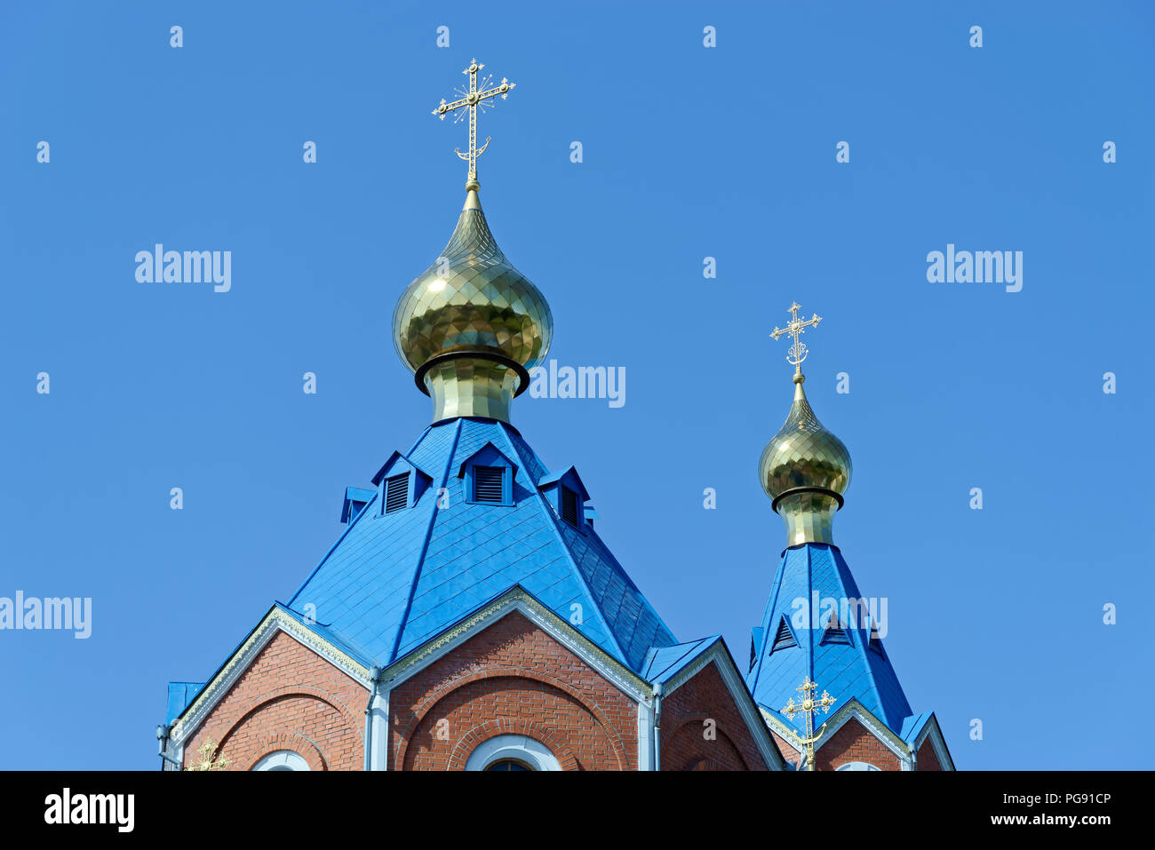 Blue roofs of russian orthodox church against clear blue sky. Cathedral of Our Lady of Kazan in Komsomolsk-on-Amur in Russia Stock Photo