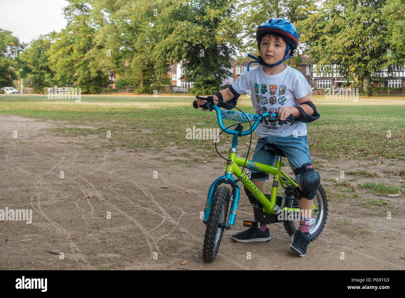 A young boy rides his bicycle in Prospect Park in Reading, UK. He is