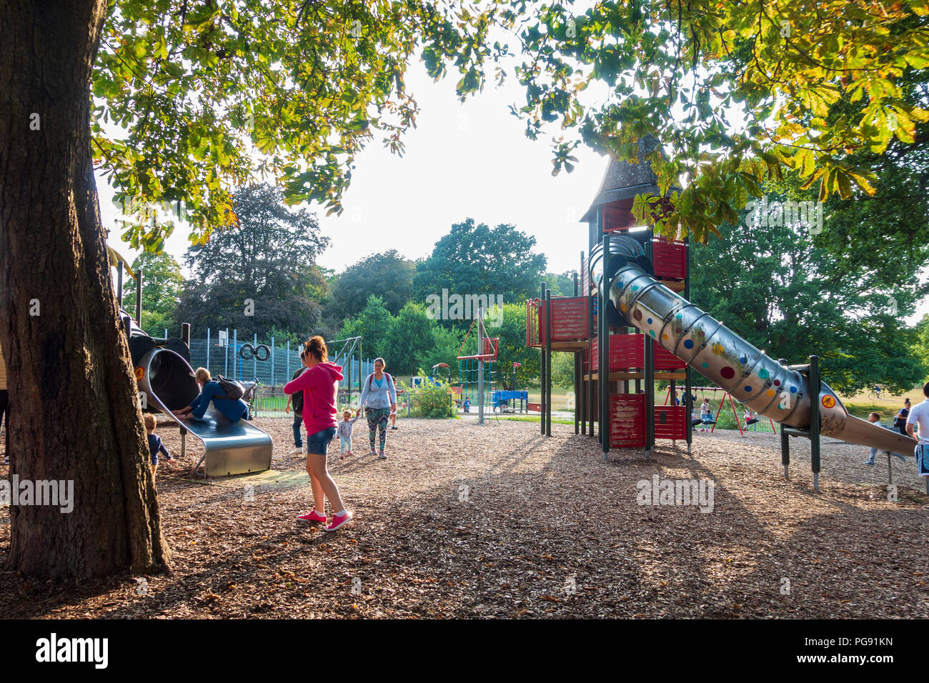 Children and parents play in the children's adventure playground in Prospect Park in Reading, UK. Stock Photo