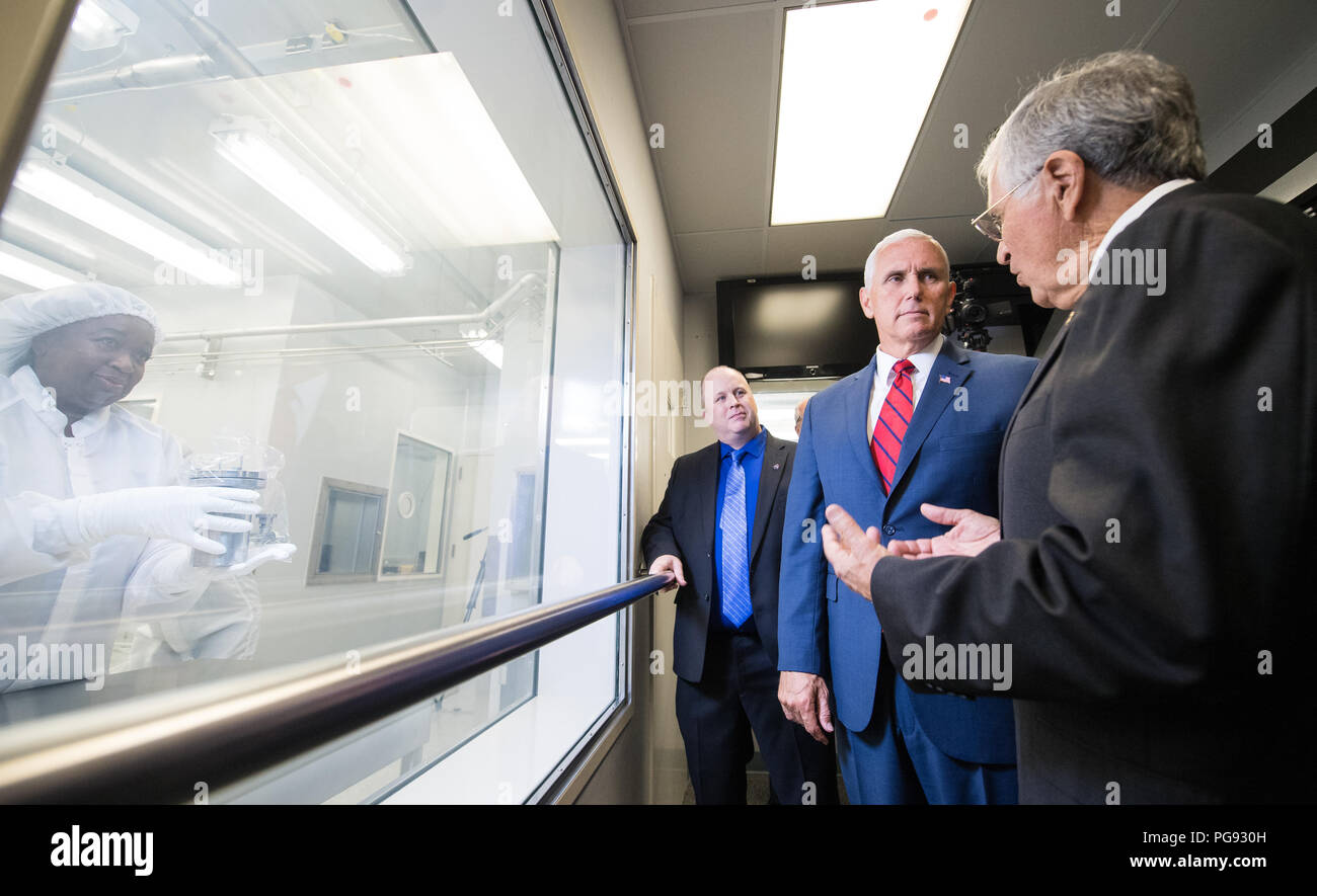 Vice President Mike Pence, center, views Sample 15014, which was collected during Apollo 15 with NASA's Apollo Sample Curator Ryan Zeigler, left, and Apollo 17 astronaut and geologist Dr. Harrison Schmitt, right, in Lunar Curation Laboratory at NASA's Johnson Space Center, Thursday, Aug. 23, 2018 in Houston, Texas. Sample 15014 is one of nine samples out of the 2,196 collected during the Apollo missions that was sealed inside its container on the Moon and still containes gasses from the Moon. Stock Photo