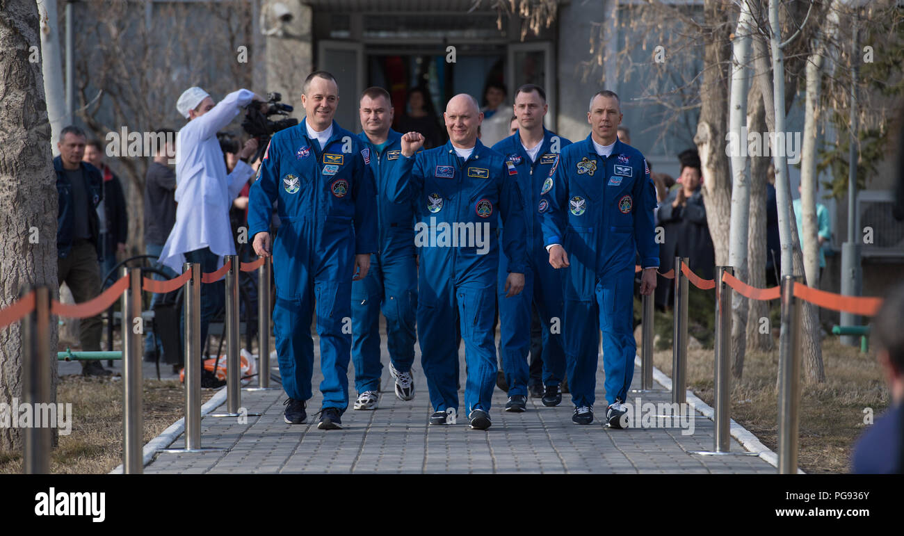 Expedition 55 flight engineer Ricky Arnold of NASA, left, Soyuz Commander Oleg Artemyev of Roscosmos, center, and flight engineer Drew Feustel of NASA, right, are seen as they depart the Cosmonaut Hotel to suit-up for their Soyuz launch to the International Space Station, Wednesday, March 21, 2018 in Baikonur, Kazakhstan. Arnold, Artemyev, and Feustel launched aboard the Soyuz MS-08 spacecraft at 1:44 p.m. Eastern time (11:44 p.m. Baikonur time) on March 21 to begin their journey to the International Space Station. Stock Photo